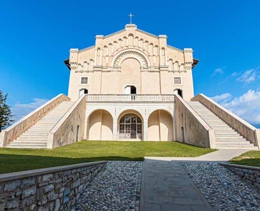 Sunlit facade of Madonna di Montecastello Sanctuary at Lake Garda.