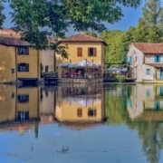 Cozy stone homes in Borghetto sul Mincio with rustic architecture, surrounded by lush greenery.