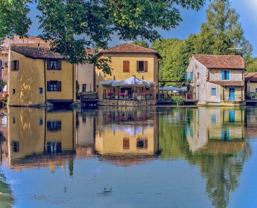 Cozy stone homes in Borghetto sul Mincio with rustic architecture, surrounded by lush greenery.