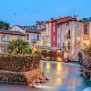 The small houses of Borghetto sul Mincio, feature picturesque stone facades and terracotta roofs, nestled beside the serene waters of the Mincio River.