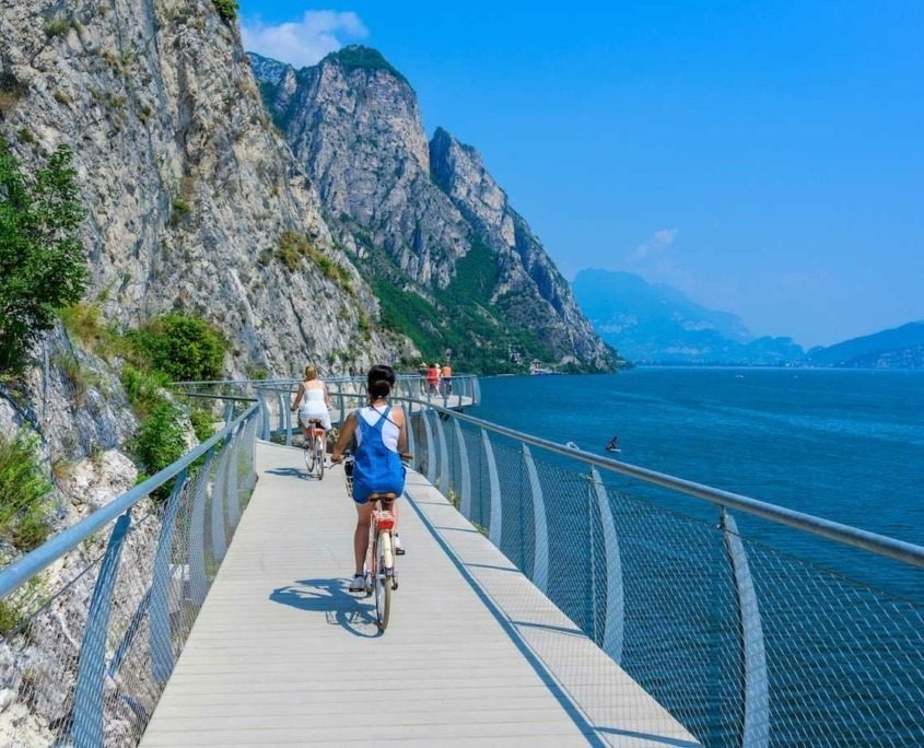 Girl riding bike on the cycling path of Limone sul Garda.