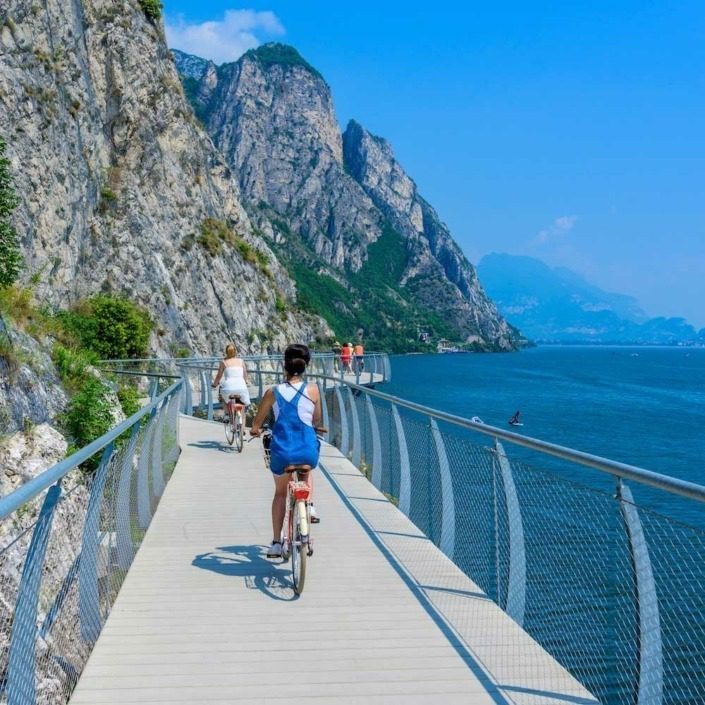 Girls riding bikes on the cycling path of Limone sul Garda.