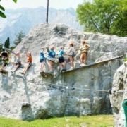 A group of people climbing a rock at Elias Adventure Park near Lake Garda.