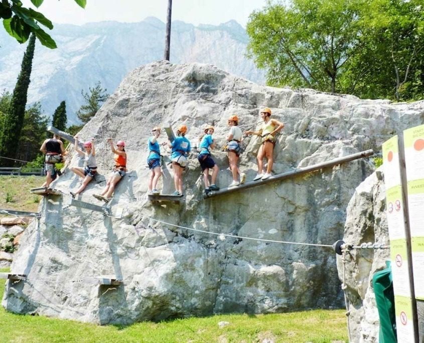 A group of people climbing a rock at Elias Adventure Park near Lake Garda.