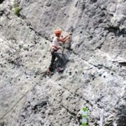 A woman climbing a rock at Elias Adventure Park.