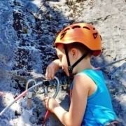 A young boy climbing a rock at Elias Adventure Park.