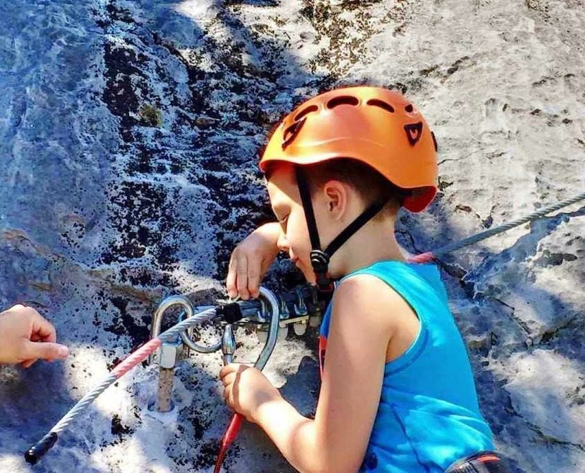 A young boy climbing a rock at Elias Adventure Park.