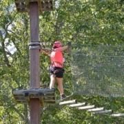 A lady crossing a Tibetan bridge at Elias Adventure Park near Lake Garda.