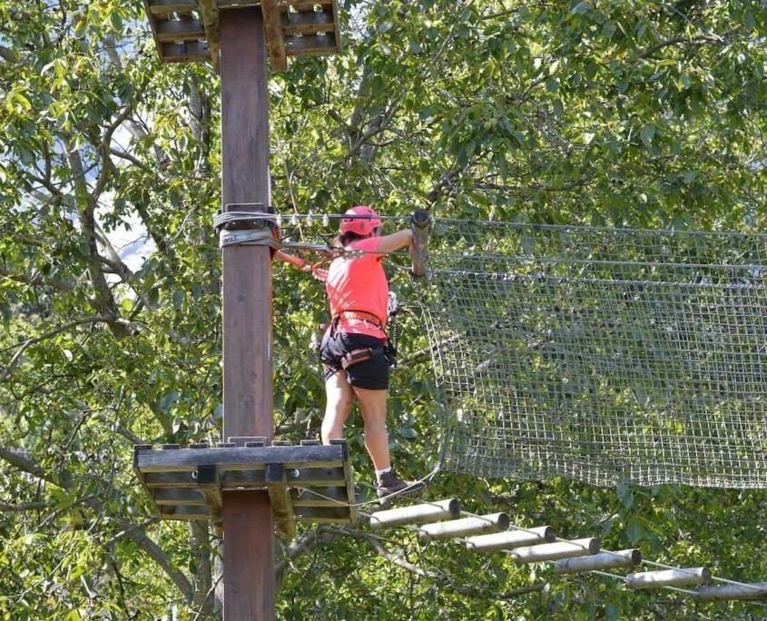 A lady crossing a Tibetan bridge at Elias Adventure Park near Lake Garda.