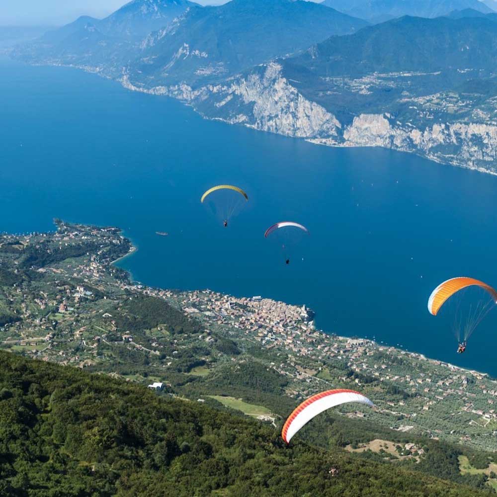 Aerial view of Lake Garda with paragliders descending from Monte Baldo.