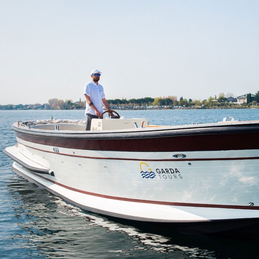 The skipper driving the water taxi boat on Lake Garda.