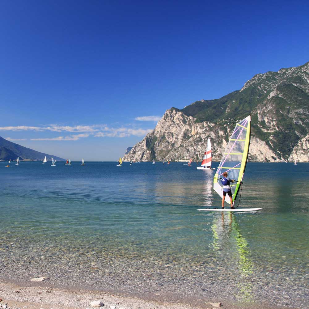 People windsurfing at Torbole Beach on Lake Garda.